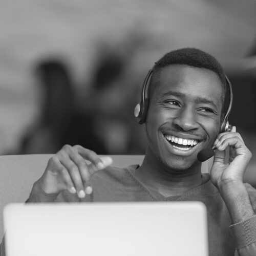 Staffing call center temp worker smiling and talking to customer through headset