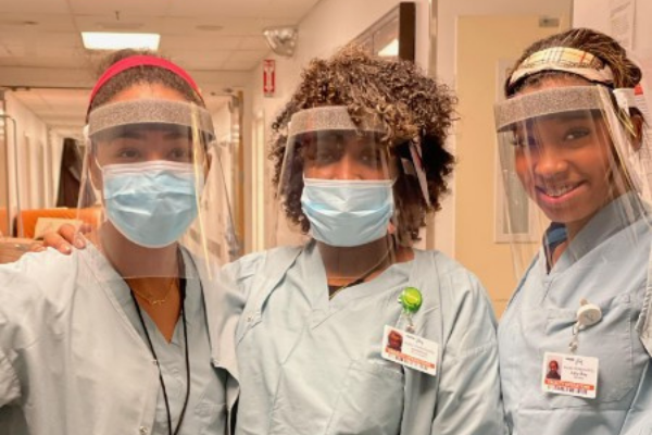 Three female TeamWRX team members stand together in California hospital.