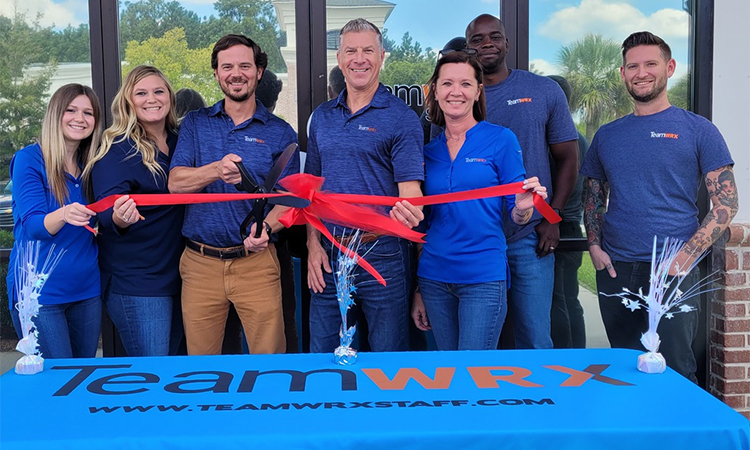 The Savannah team standing in front of the grand opening of their new office